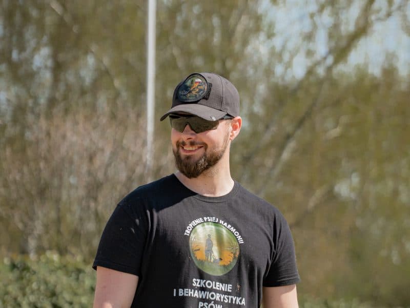 Filip Kaźmierczak w koszulce Tropienie Psiej Harmonii na terenie treningowym